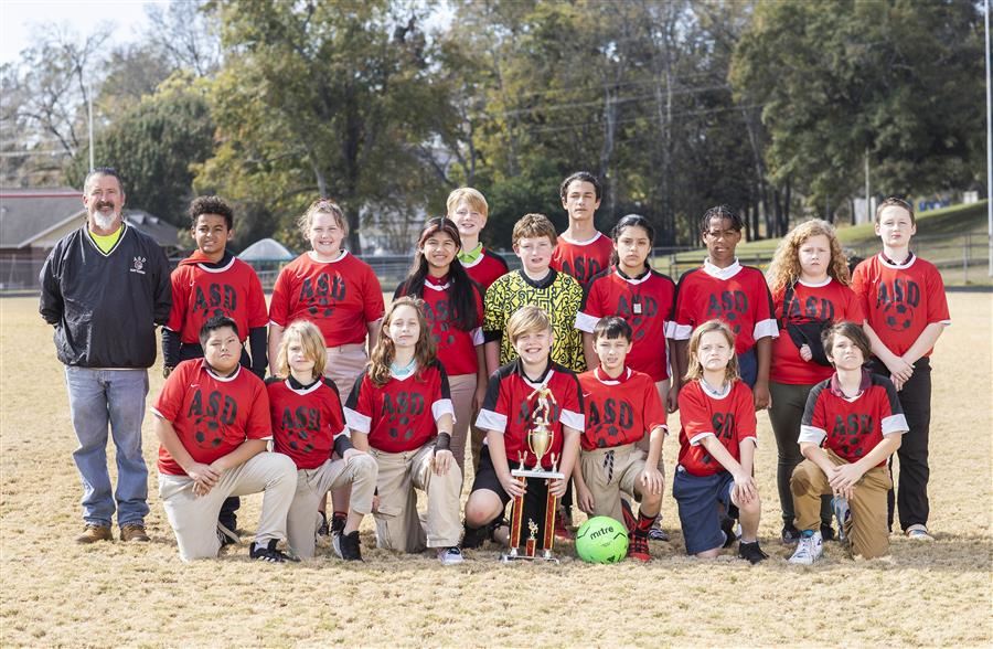 Member of the ASD Major Rec League soccer team pose for a team photo in front of soccer net.